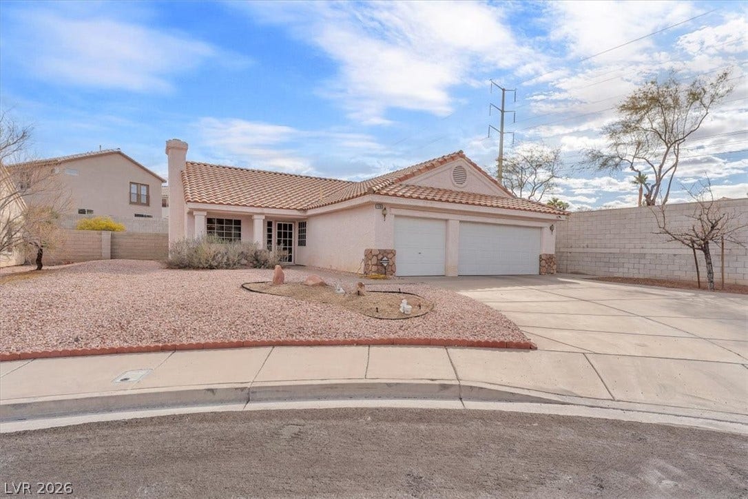 1163 Teal Point Drive, Henderson, NV 89074 View of front facade featuring a tile roof, stucco siding, fence, a garage, and driveway