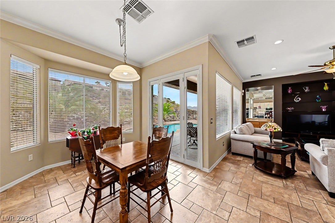 2306 Schaeffer Hills Drive, Henderson, NV 89052 A relaxed dining space opens to a refreshing outdoor pool area, perfect for seamless indoor-outdoor living.