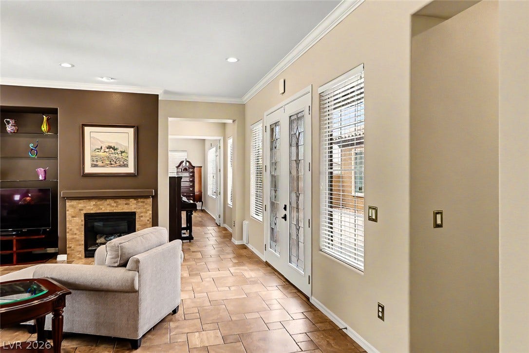 2306 Schaeffer Hills Drive, Henderson, NV 89052 A welcoming entryway with tiled flooring leads into a comfortable living space featuring a cozy fireplace.
