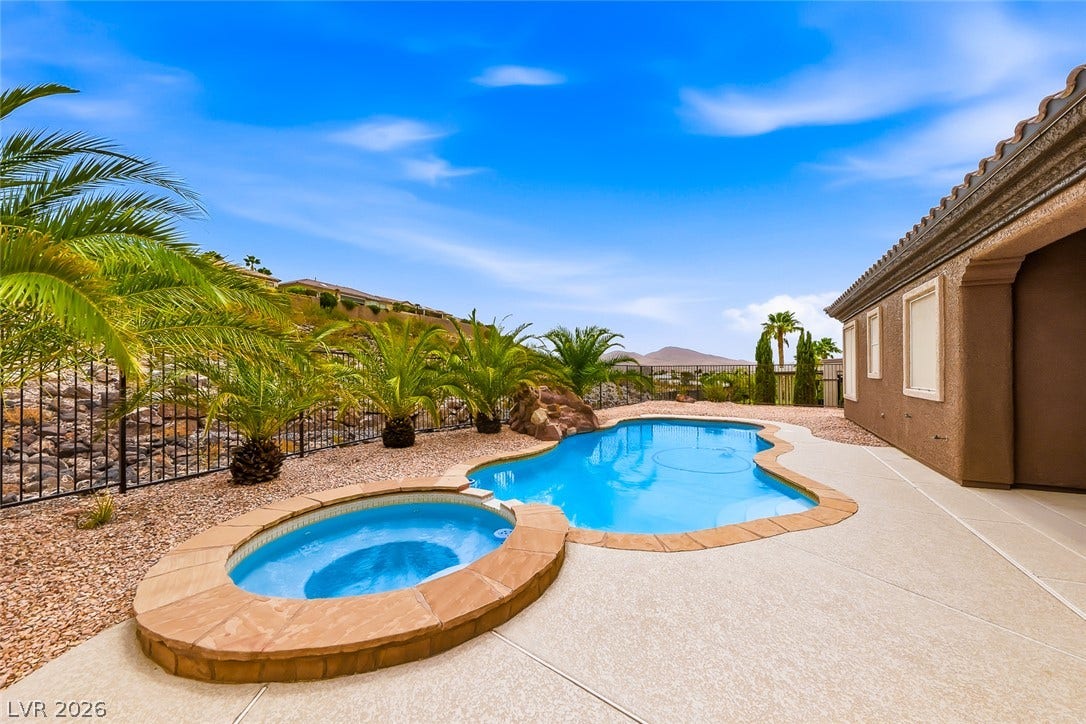 2306 Schaeffer Hills Drive, Henderson, NV 89052 An inviting backyard oasis offers a freeform pool and a separate hot tub, surrounded by drought-tolerant landscaping and mountain views.