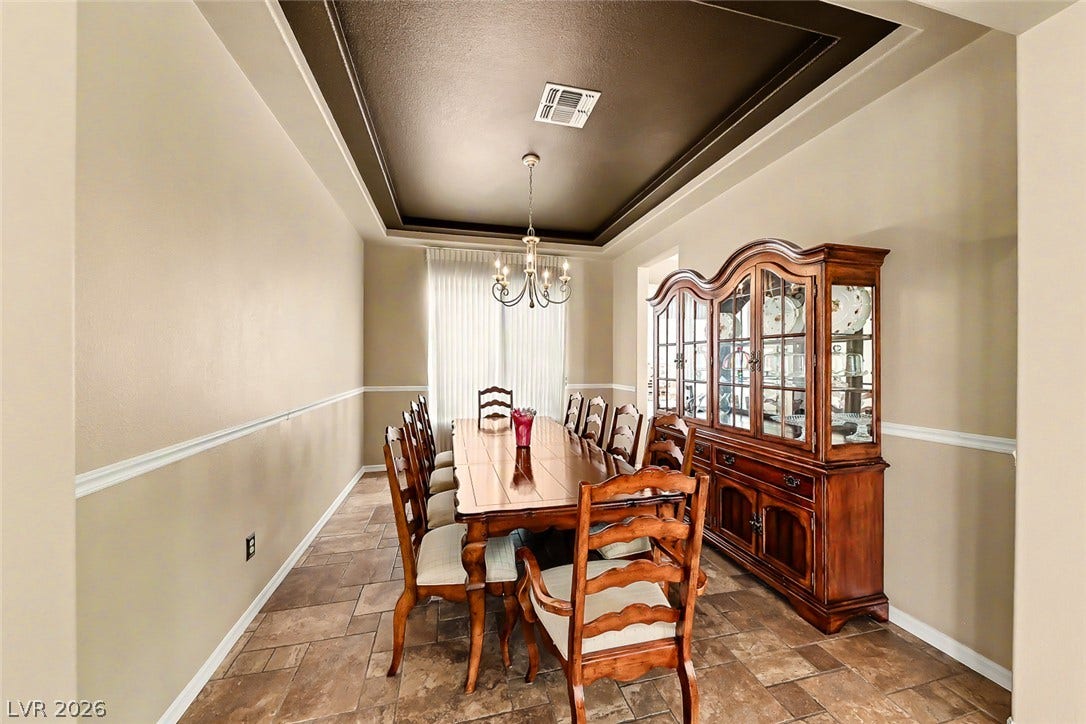 2306 Schaeffer Hills Drive, Henderson, NV 89052 A formal dining area featuring a tray ceiling and sophisticated lighting, perfect for entertaining.