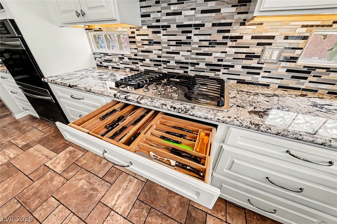 2306 Schaeffer Hills Drive, Henderson, NV 89052 Culinary delights await in this chef's kitchen featuring a sleek gas range and ample granite counter space.
