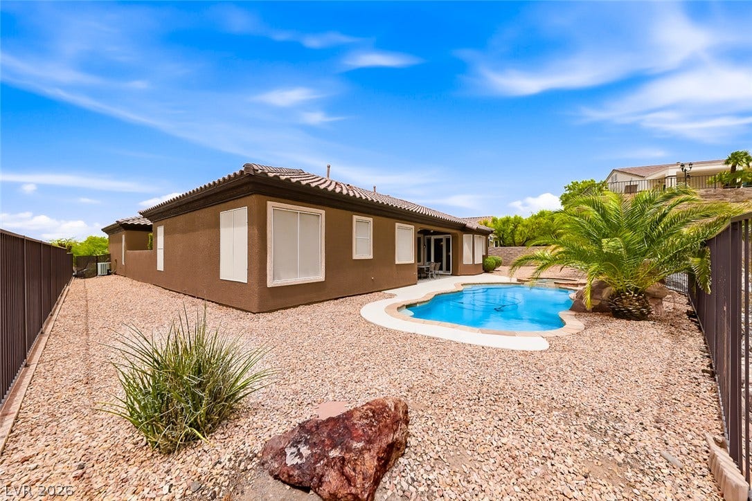 2306 Schaeffer Hills Drive, Henderson, NV 89052 A desert oasis, featuring a glistening in-ground pool and low-maintenance landscaping under a vast blue sky.