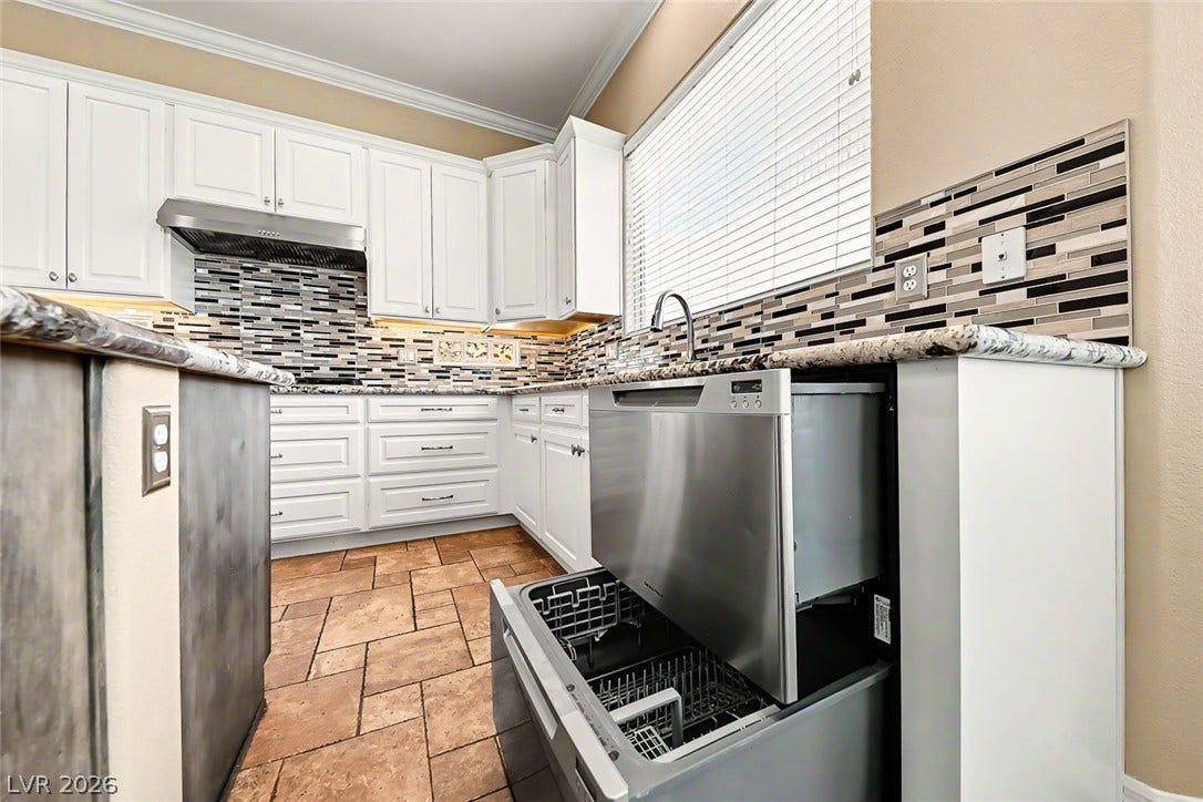 2306 Schaeffer Hills Drive, Henderson, NV 89052 A well-appointed kitchen showcasing elegant cabinetry, durable countertops, and a tasteful tiled backsplash.