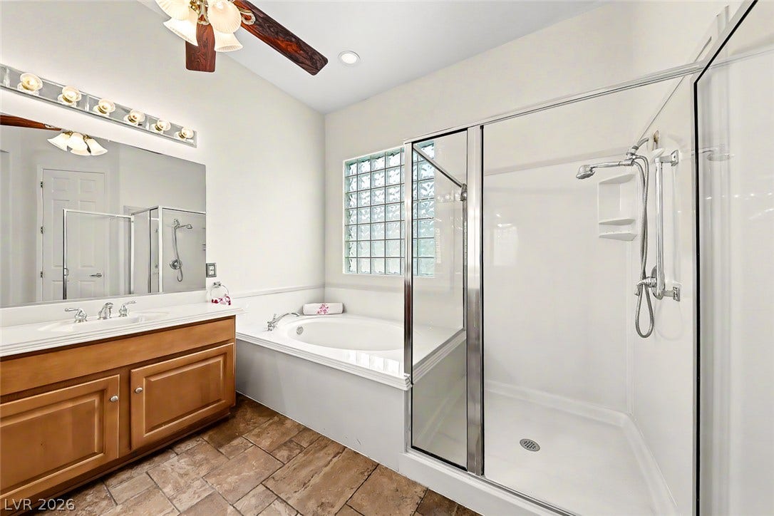 2306 Schaeffer Hills Drive, Henderson, NV 89052 Dual vanities and a tiled walk-in shower complement a separate soaking tub for luxurious bathing.