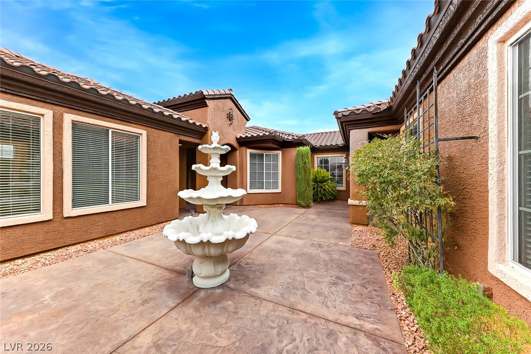 2306 Schaeffer Hills Drive, Henderson, NV 89052 A tranquil courtyard entry with a tiered fountain and patterned concrete flooring welcomes guests.