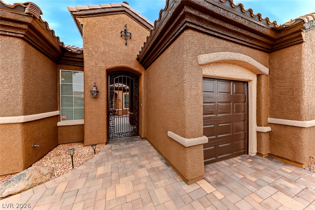 2306 Schaeffer Hills Drive, Henderson, NV 89052 A private courtyard entry welcomes you to this stucco home with a tile roof and attached garage.