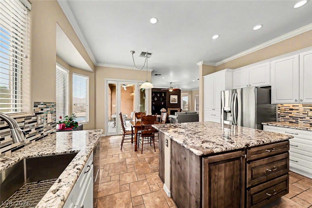 2306 Schaeffer Hills Drive, Henderson, NV 89052 A well-appointed culinary space featuring granite counters, stainless steel appliances, and a central island.