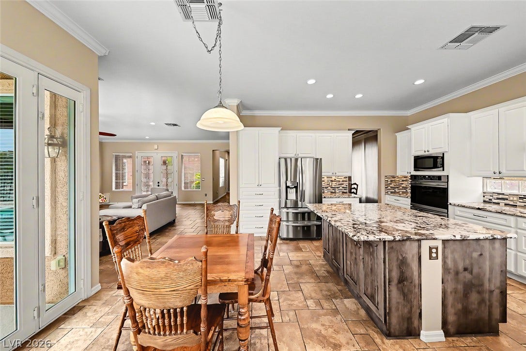 2306 Schaeffer Hills Drive, Henderson, NV 89052 An inviting eat-in kitchen with a large island and ample cabinet space seamlessly flows into the living area.