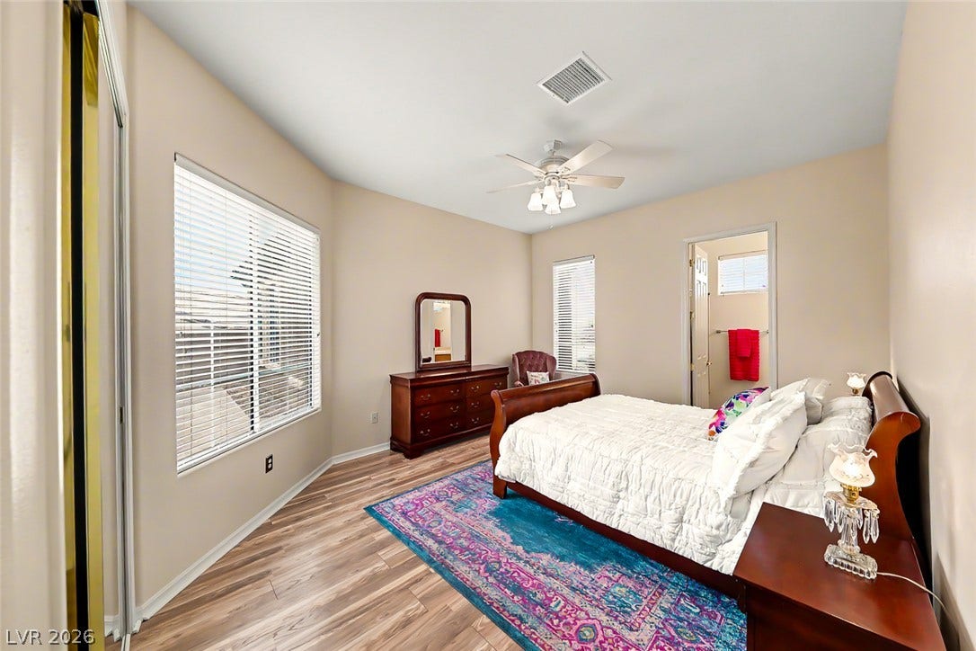 2306 Schaeffer Hills Drive, Henderson, NV 89052 Well-lit sleeping quarters with rich wood flooring and a refreshing ceiling fan.