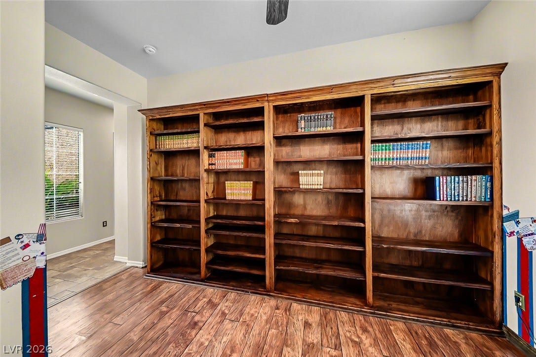 2306 Schaeffer Hills Drive, Henderson, NV 89052 Rich wood floors and a wall of built-in shelving create a distinguished study.