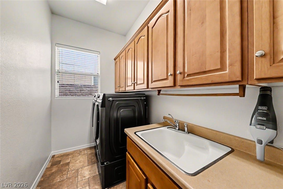 2306 Schaeffer Hills Drive, Henderson, NV 89052 Practical laundry area with ample cabinetry, a utility sink, and durable flooring.