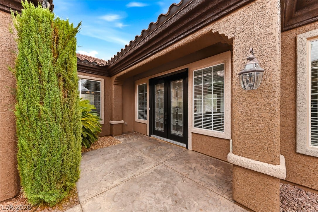 2306 Schaeffer Hills Drive, Henderson, NV 89052 Elegant leaded glass entry doors welcome you to this charming residence with a covered front porch.