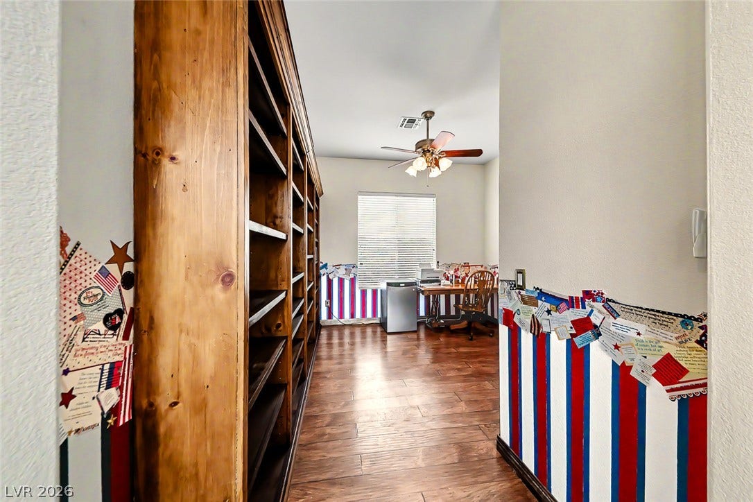 2306 Schaeffer Hills Drive, Henderson, NV 89052 An inviting study features extensive built-in shelving, rich wood flooring, and a window with natural illumination.