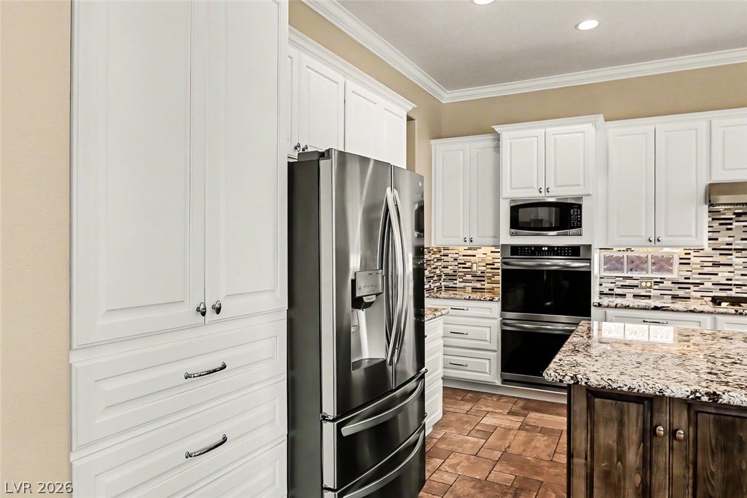 2306 Schaeffer Hills Drive, Henderson, NV 89052 Well-appointed kitchen showcases bright cabinetry, gleaming countertops, and modern appliances, creating an inviting culinary space.
