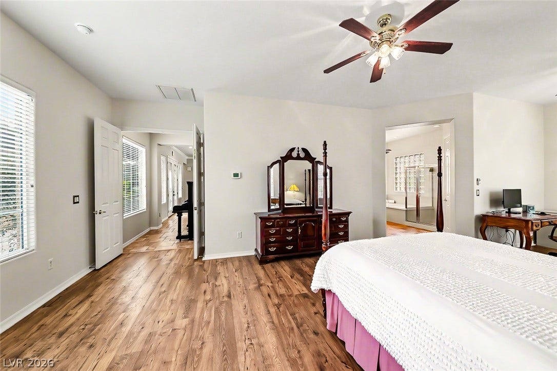 2306 Schaeffer Hills Drive, Henderson, NV 89052 A naturally illuminated primary bedroom offers rich wood flooring and direct access to a private bathroom retreat.