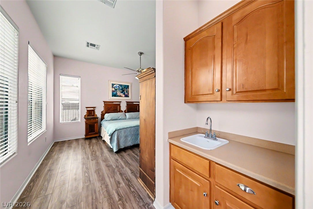 2306 Schaeffer Hills Drive, Henderson, NV 89052 A clever laundry area with a dedicated sink and ample cabinetry adjoins a sun-drenched bedroom.