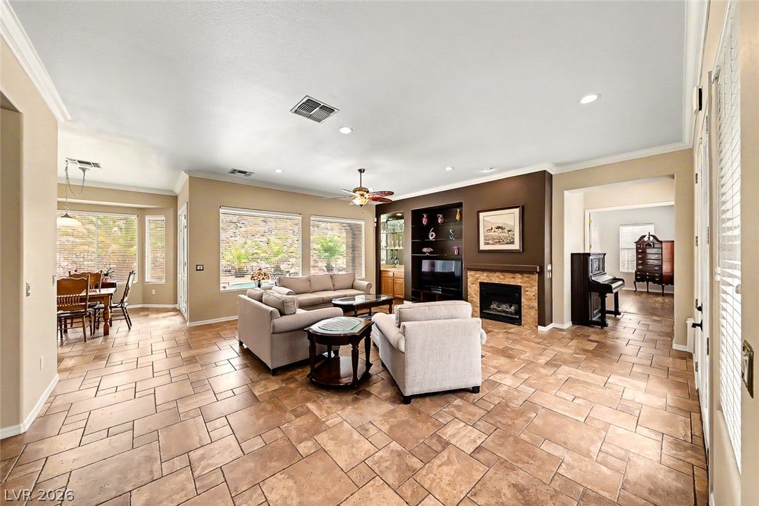 2306 Schaeffer Hills Drive, Henderson, NV 89052 A generously proportioned living area features a warm fireplace and ample natural light, flowing into a dining space.