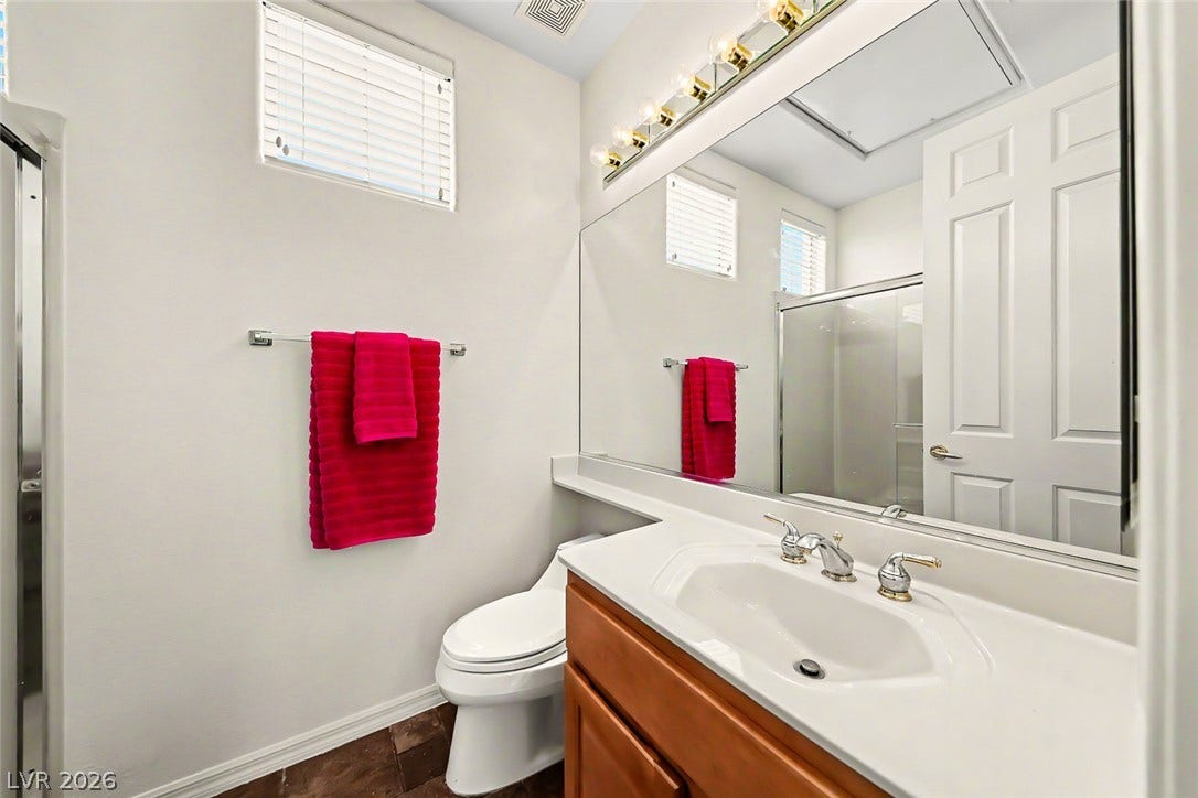 2306 Schaeffer Hills Drive, Henderson, NV 89052 A compact, functional bathroom features a single vanity, toilet, and a glass-enclosed shower.