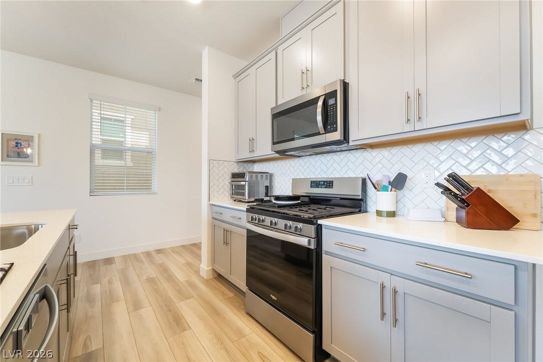2966 Gallarate Drive, Henderson, NV 89044 Culinary adventures await in this kitchen, featuring sleek stainless steel appliances and durable hardwood flooring.