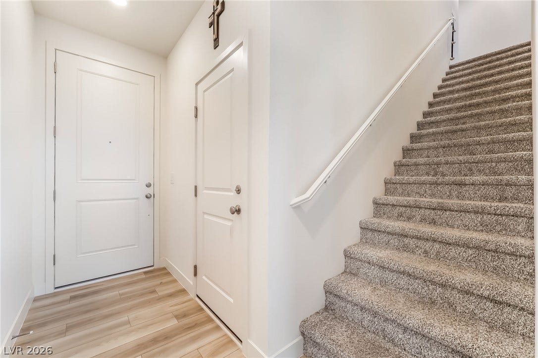 2966 Gallarate Drive, Henderson, NV 89044 A welcoming entryway features light wood flooring and a carpeted staircase with a clean white railing.