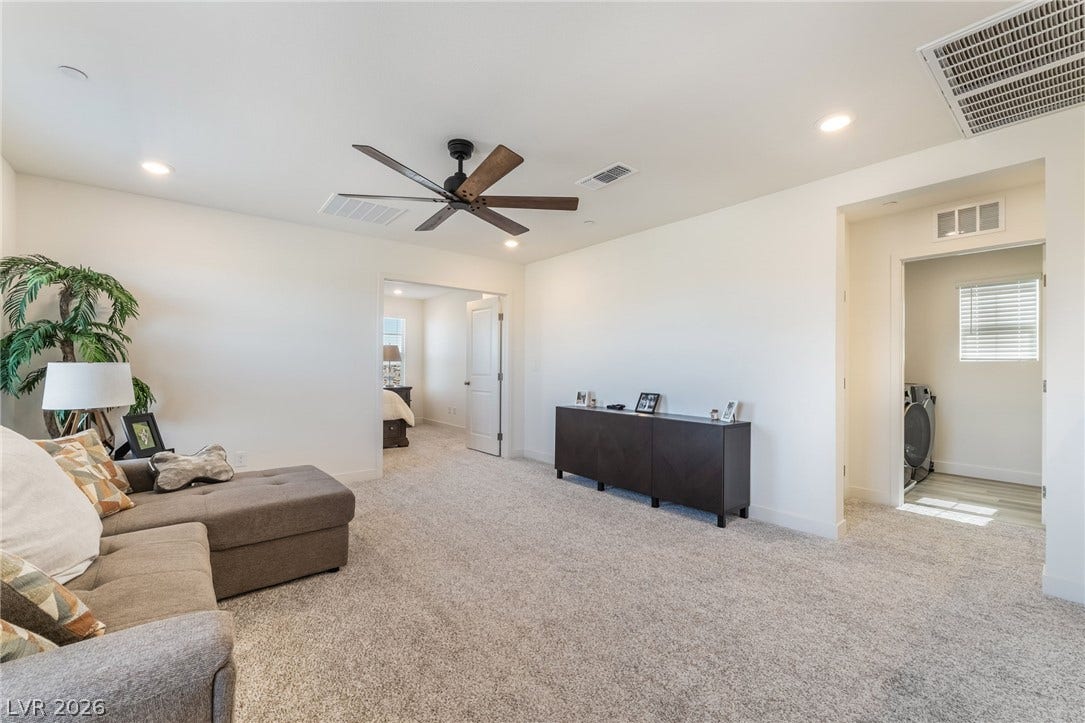 2966 Gallarate Drive, Henderson, NV 89044 A well-lit bonus room features soft carpeting and a ceiling fan, offering a comfortable space for relaxation.