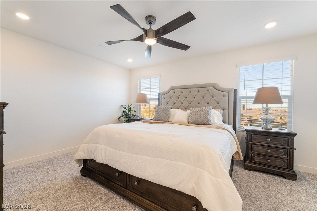 2966 Gallarate Drive, Henderson, NV 89044 A well-lit bedroom features plush carpeting and a stylish ceiling fan with integrated lighting.