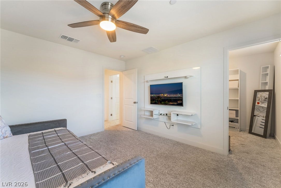 2966 Gallarate Drive, Henderson, NV 89044 A well-appointed bedroom includes plush carpeting and a modern entertainment wall.