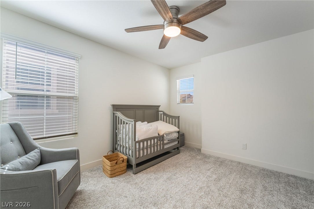 2966 Gallarate Drive, Henderson, NV 89044 A well-lit bedroom features plush carpeting and a modern ceiling fan, creating a comfortable environment.