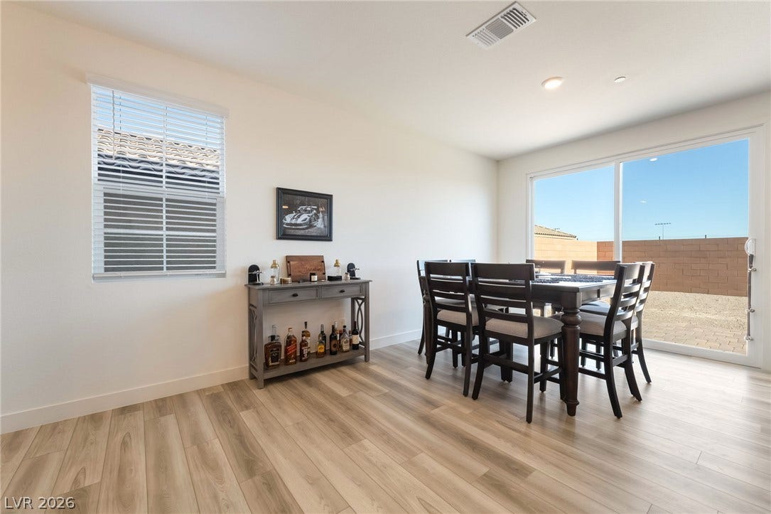 2966 Gallarate Drive, Henderson, NV 89044 A well-lit dining area featuring plank flooring and a sliding glass door for outdoor access.