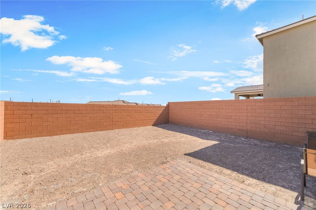 2966 Gallarate Drive, Henderson, NV 89044 A spacious, gravel-filled backyard offers a blank canvas for personalized landscaping, bordered by privacy walls and an inviting paver patio.