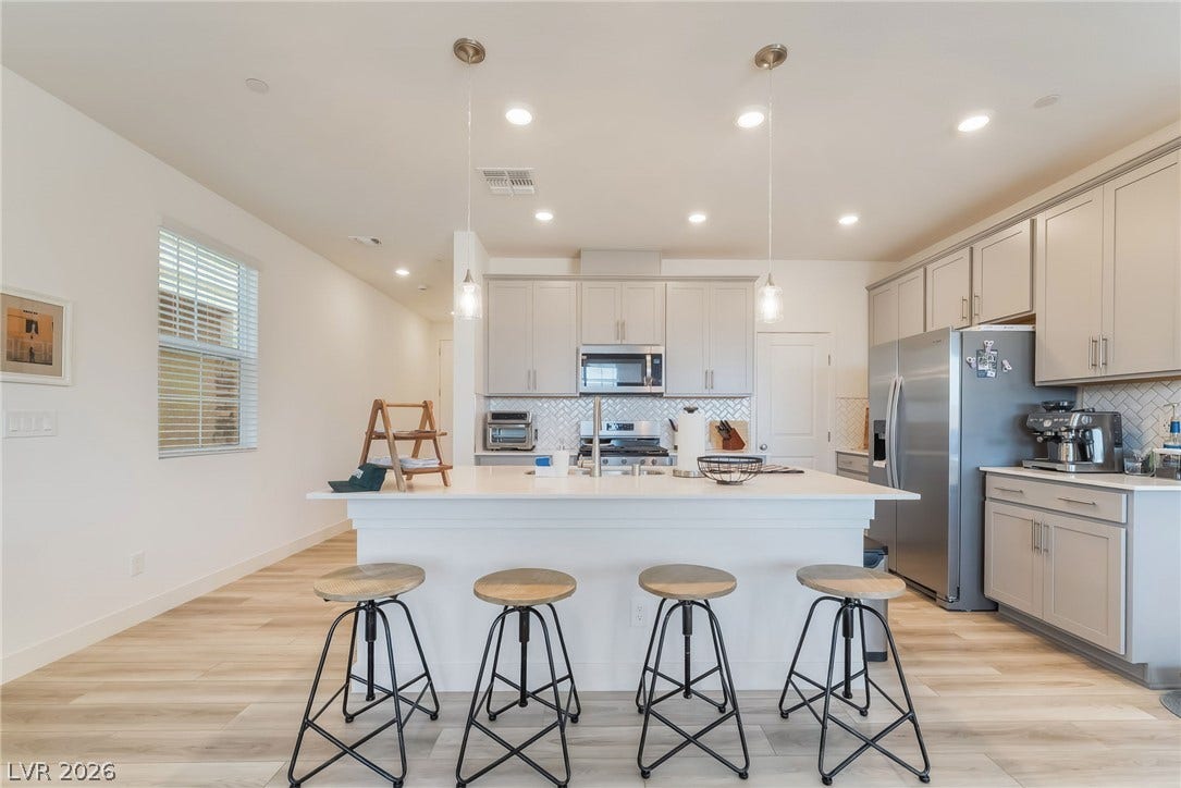 2966 Gallarate Drive, Henderson, NV 89044 A contemporary kitchen features an inviting island with casual seating, recessed lighting, and stainless steel appliances.