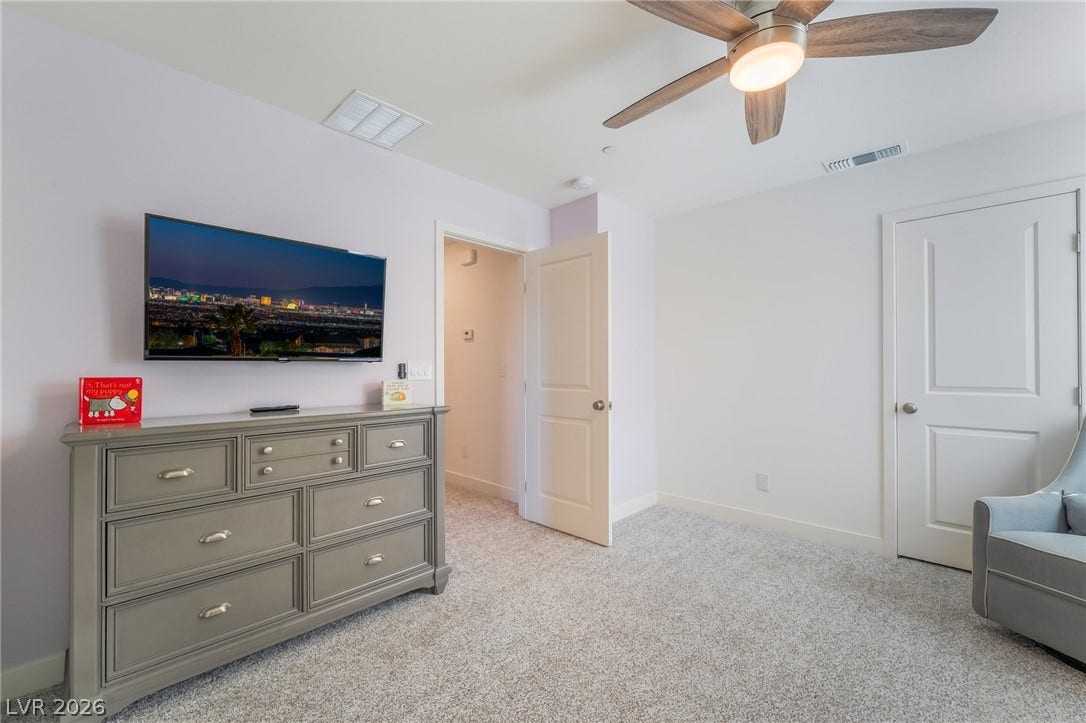 2966 Gallarate Drive, Henderson, NV 89044 A well-lit room showcases plush carpeting and a modern ceiling fan, offering a comfortable personal retreat.