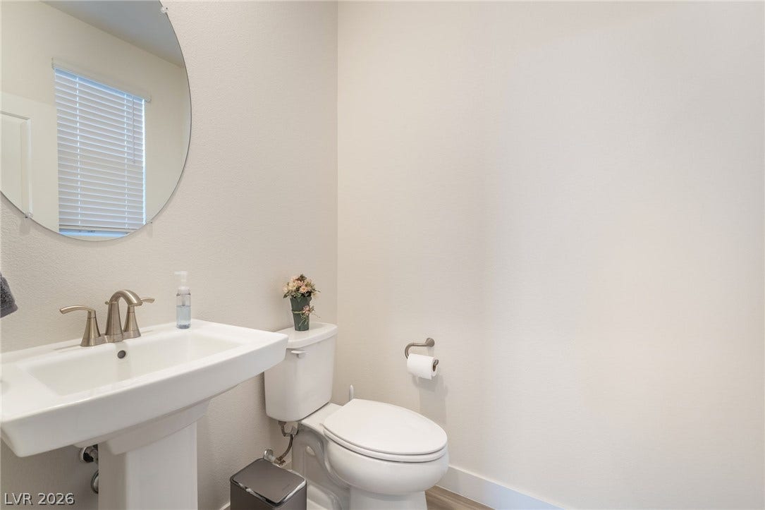 2966 Gallarate Drive, Henderson, NV 89044 A pristine powder room offers a sleek pedestal sink and contemporary fixtures, providing essential comfort.
