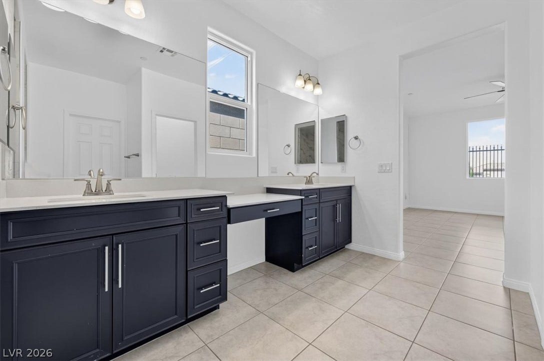 Dual vanities with ample counter space and a built-in makeup area offer convenience and style.