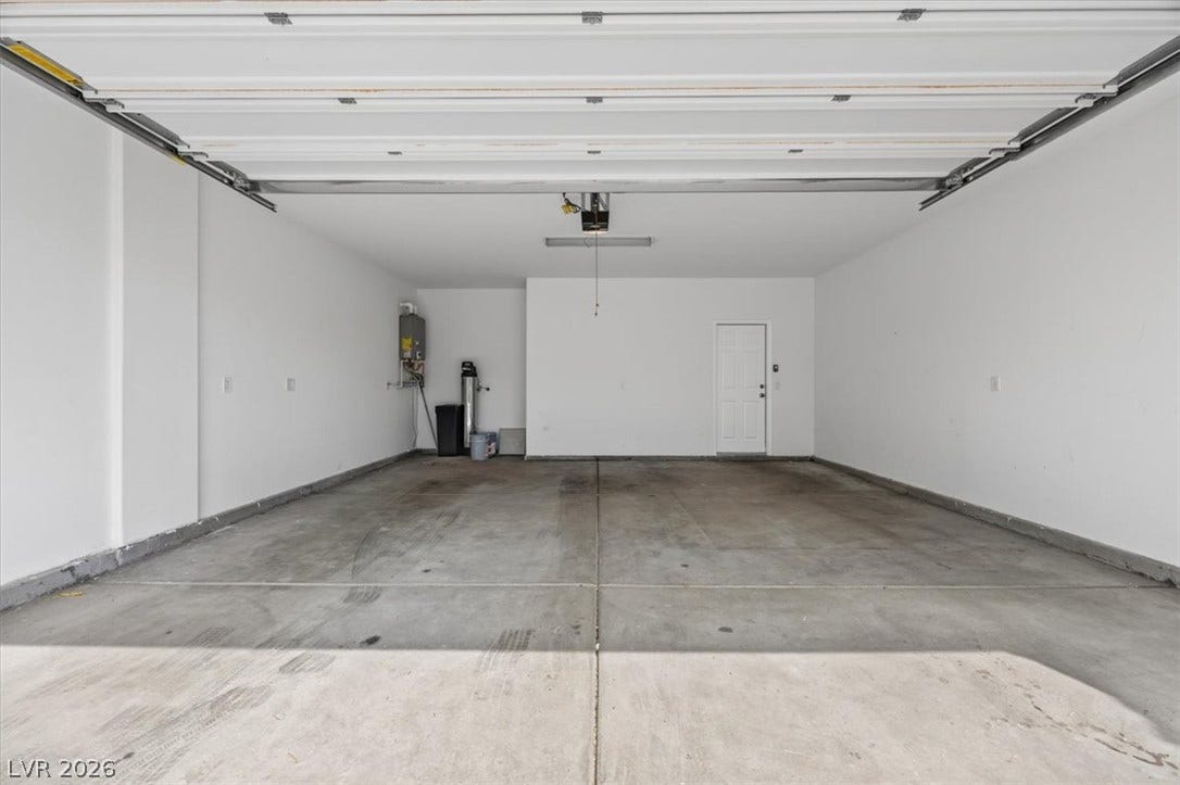 A spacious, well-lit garage offers ample parking and additional storage solutions.