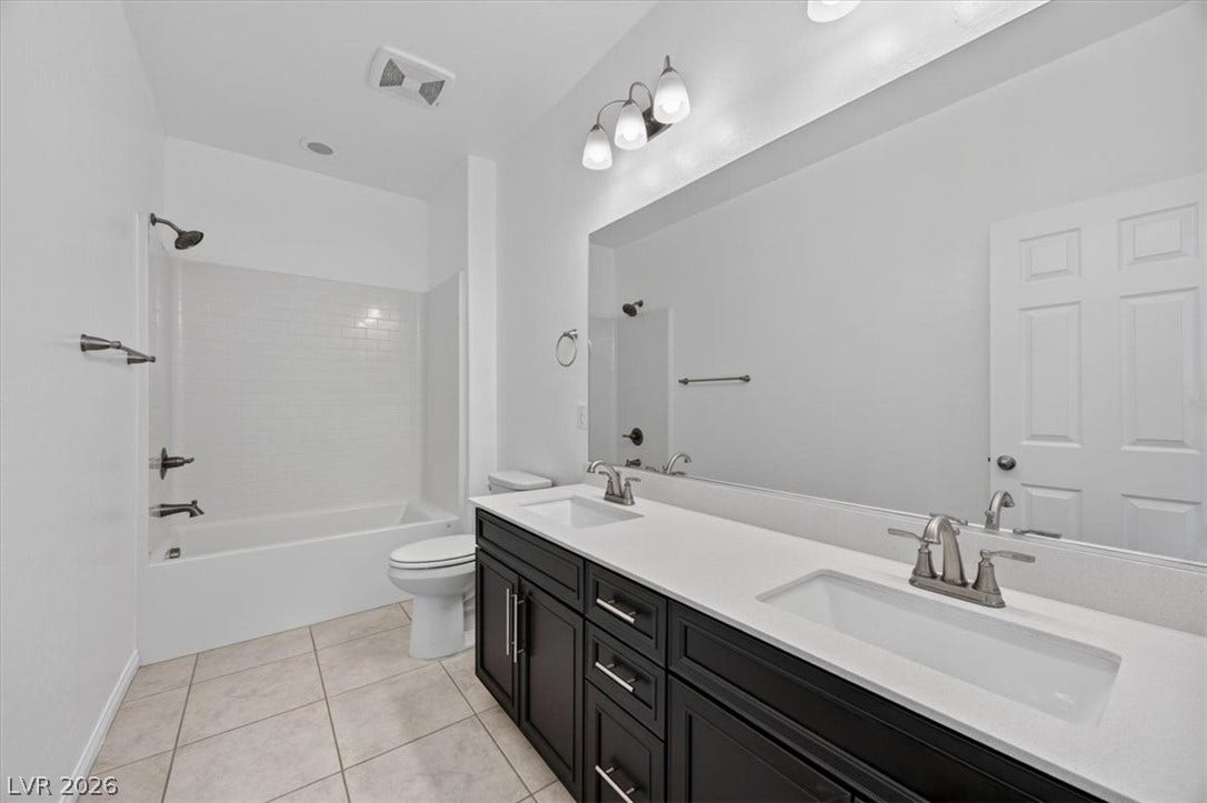 A well-appointed bath features a double vanity and sleek fixtures, perfect for daily routines.