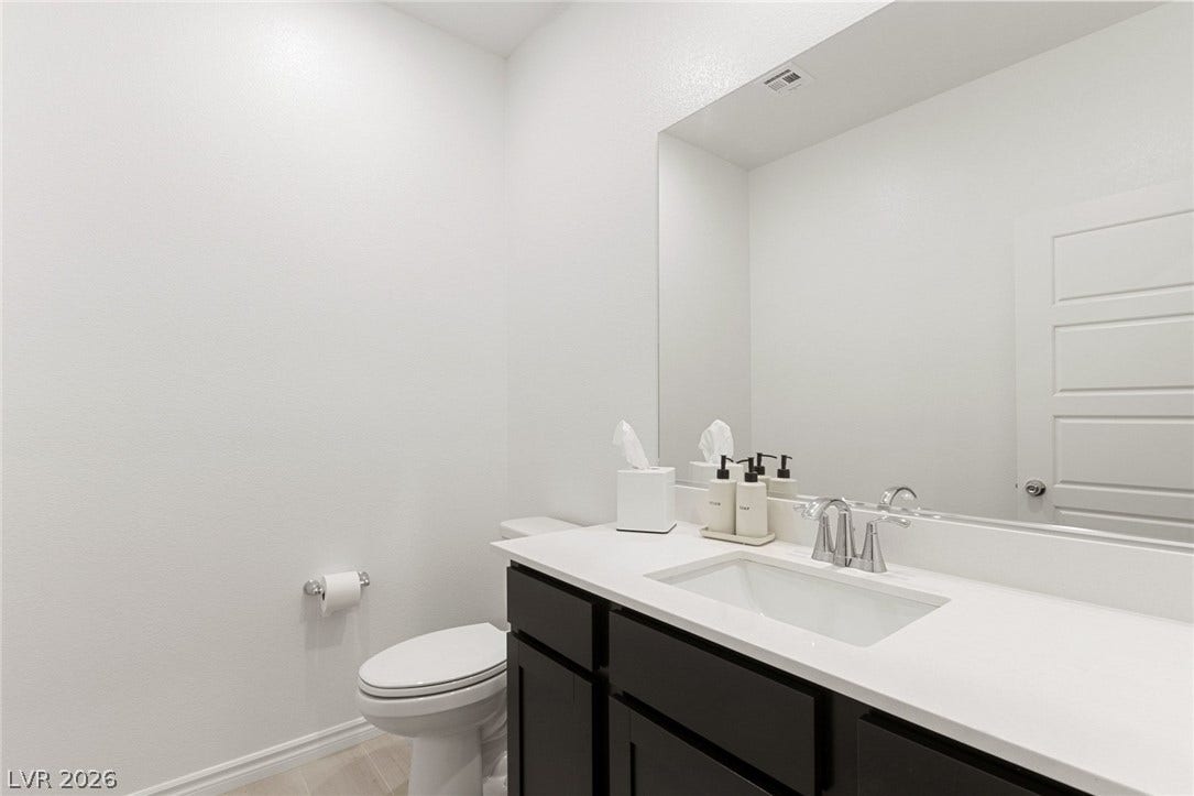 9986 Joshua Foothills Street, Las Vegas, NV 89178 A bright, clean bathroom features a sleek vanity with a wide mirror and modern fixtures.