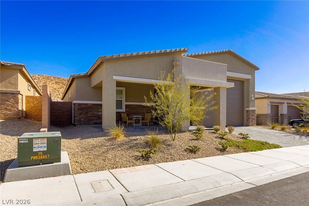 9986 Joshua Foothills Street, Las Vegas, NV 89178 A desert-friendly front yard frames this contemporary home, featuring a welcoming covered entry and an attached garage.