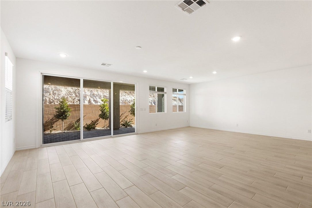 9986 Joshua Foothills Street, Las Vegas, NV 89178 A spacious living area with sleek tile flooring and ample natural light from large sliding glass doors.