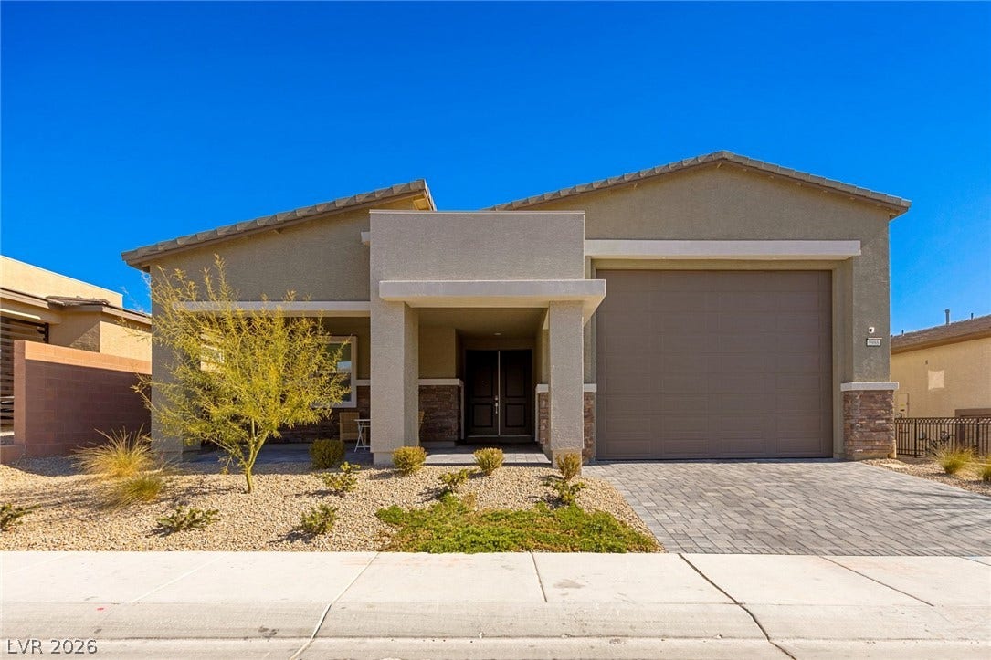 9986 Joshua Foothills Street, Las Vegas, NV 89178 A desert-friendly landscape surrounds this welcoming home with a paver driveway leading to the garage and front entrance.