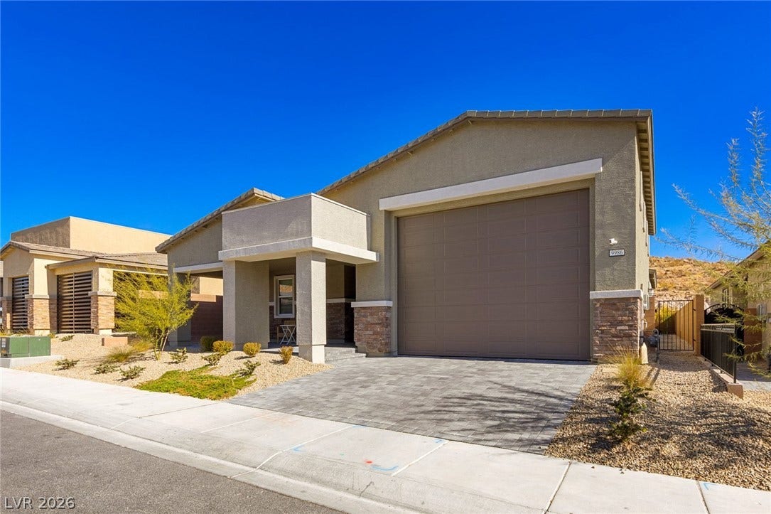 9986 Joshua Foothills Street, Las Vegas, NV 89178 A modern home showcases a paver driveway, an inviting front entry, and drought-tolerant landscaping under clear skies.