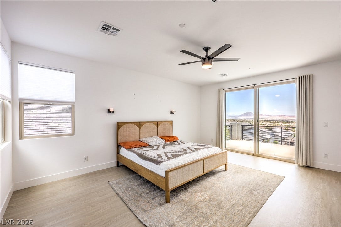 1984 Canyon Highlands Drive, Henderson, NV 89052 A well-lit bedroom features durable laminate flooring and direct access to a private balcony with panoramic mountain views.