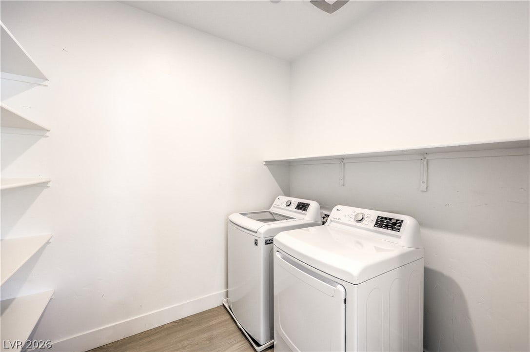 1984 Canyon Highlands Drive, Henderson, NV 89052 Functional laundry space featuring a full-size washer and dryer with convenient wall shelving for storage.