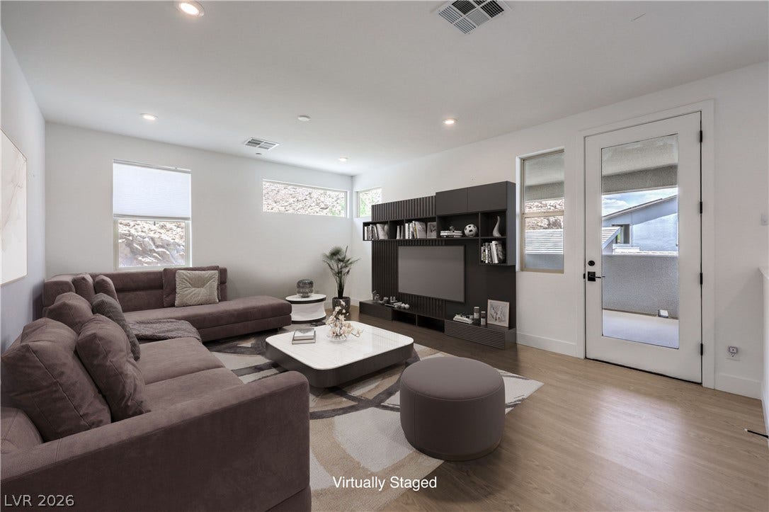 1984 Canyon Highlands Drive, Henderson, NV 89052 Recessed lighting illuminates a well-appointed living room featuring wood flooring and a glass-paned door.