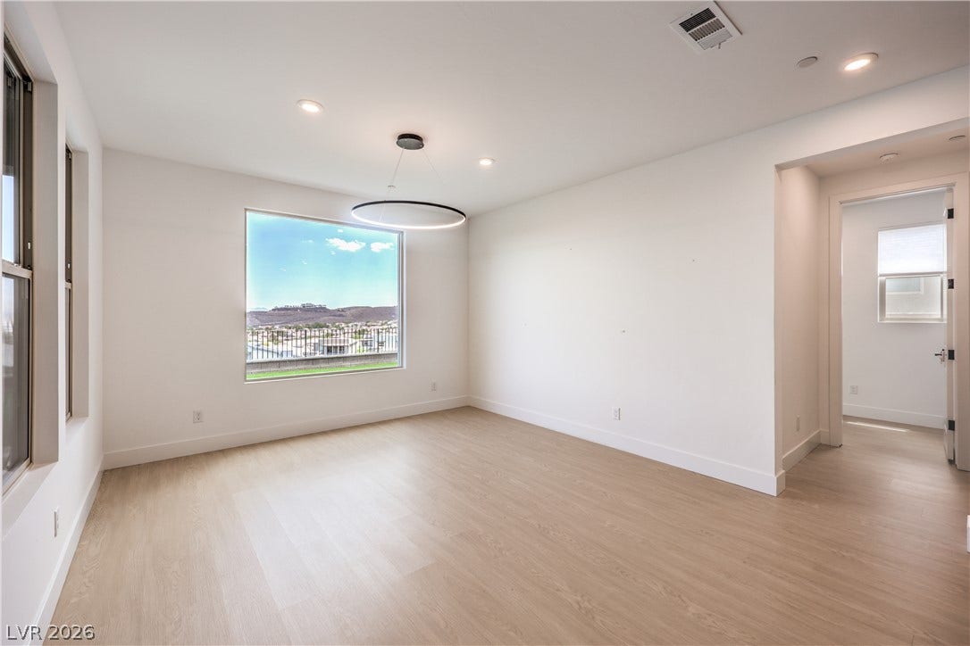 1984 Canyon Highlands Drive, Henderson, NV 89052 A luminous living space features wide plank flooring and a broad window showcasing distant hills.