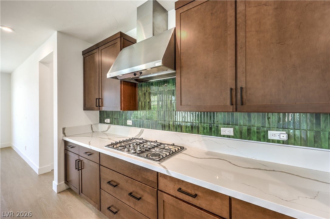 1984 Canyon Highlands Drive, Henderson, NV 89052 Culinary delights await in this modern kitchen featuring a gas cooktop, sleek range hood, and ample cabinetry.