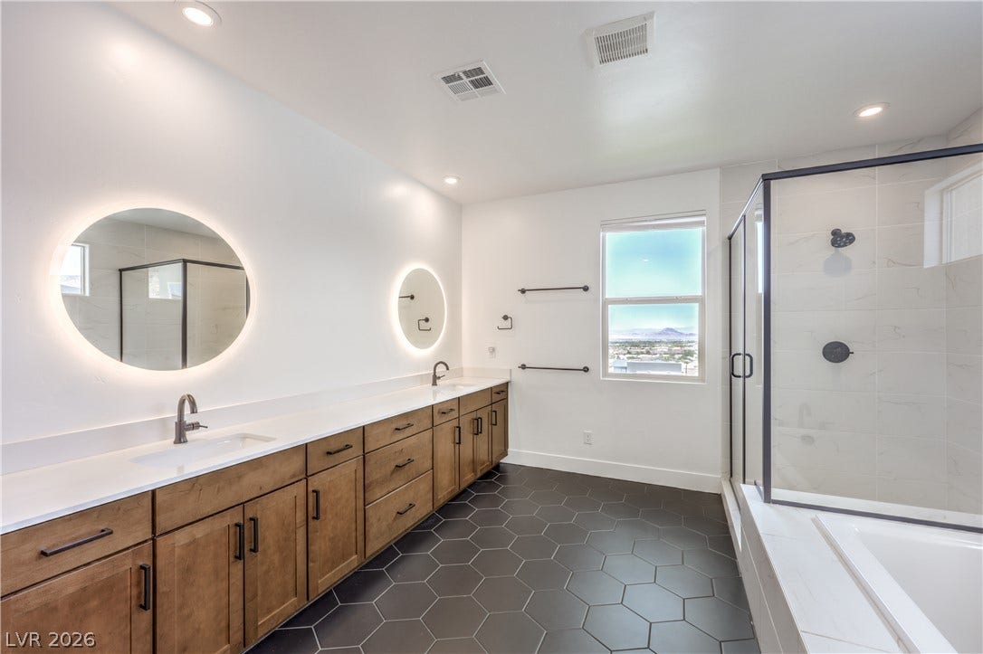 1984 Canyon Highlands Drive, Henderson, NV 89052 A sleek bathroom features dual sinks, modern cabinetry, and a spacious glass-enclosed shower.