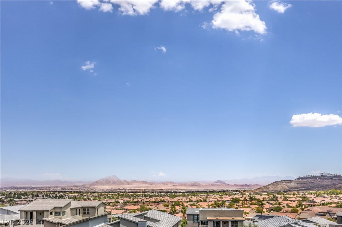 1984 Canyon Highlands Drive, Henderson, NV 89052 An impressive panorama showcases desert mountains and distant city lights beyond residential rooftops.