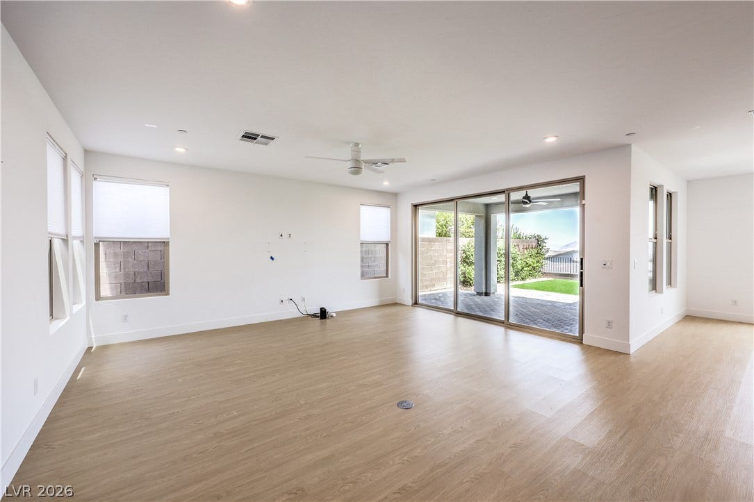 1984 Canyon Highlands Drive, Henderson, NV 89052 A versatile living area with light wood flooring and direct access to an outdoor patio and green space.
